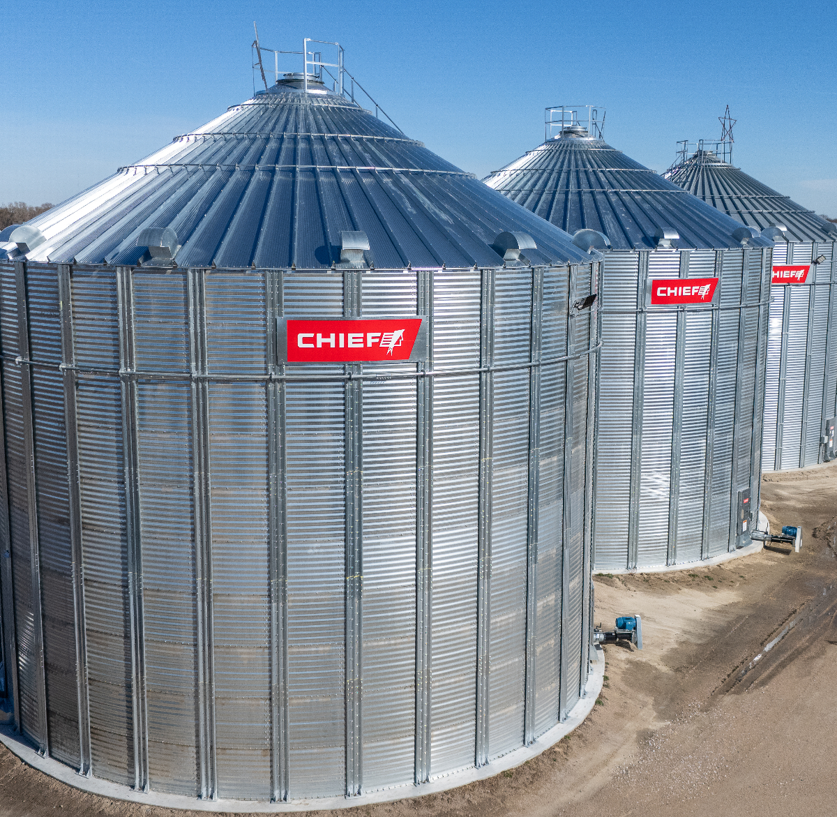 A row of three metal grain bins made by Chief Agri.