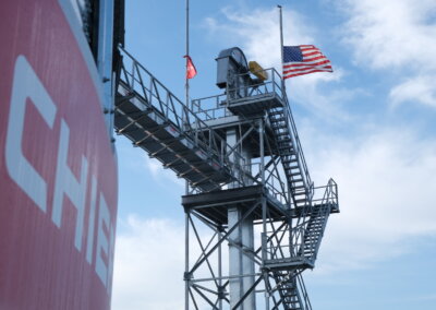 American flags at half-mast flying above the Chief Tower at The All American Farm during Husker Harvest Days 2025.