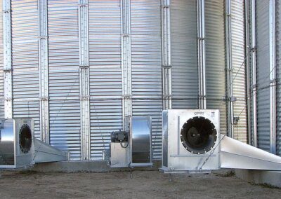Two large grain bins with fans.