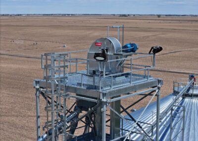 Closeup of a Chief Agri grain elevator with harvested field in the background.